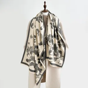 Elegant vintage floral cashmere-feel scarf with tassels on beige wool coat