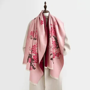 Dettaglio del motivo floreale e dei bordi sfrangiati sullo scialle in cashmere rosa
