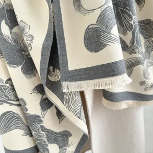 Close-up of vintage floral and swan patterns on soft cream pashmina with tassel edges