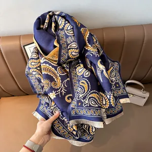 Close-up of navy paisley pattern double-sided scarf with fringe and soft wool texture