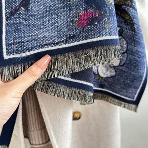 Detailaufnahme des blauen Jacquard-Kaschmir-Schals mit Fransen und Blumenmuster