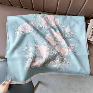 Dettaglio dello scialle in cashmere blu-grigio con fiori di prugno rosa e frange
