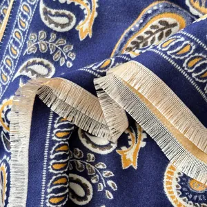 Close-up of navy paisley print scarf with beige fringe details and soft woven texture