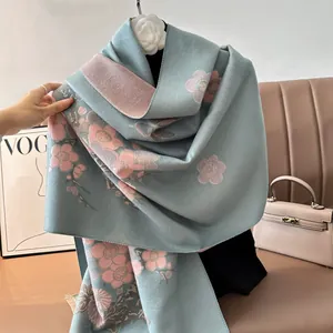 Dettaglio della trama morbida e del motivo floreale blu dello scialle effetto cashmere