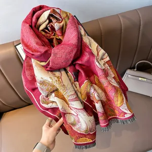 Détail d'une écharpe en cachemire rouge à motif floral et bords à franges