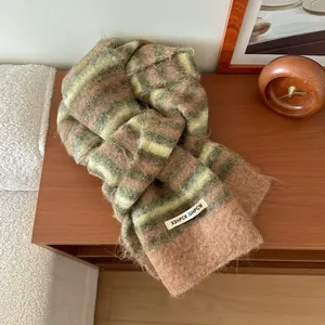 Détail de l'écharpe en laine rayée avec texture duveteuse et étiquette minimaliste