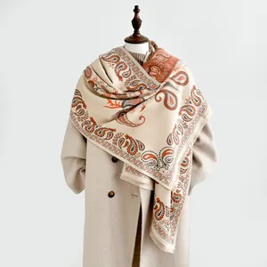 Detail of winter paisley pashmina shawl with fringes over a wool coat for women