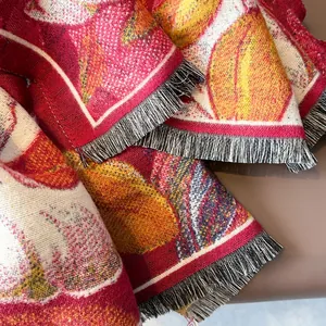 Détail du motif floral jacquard et des franges noires et blanches sur châle épais