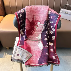 Winter faux cashmere scarf featuring a cute cat pattern and tassel edges on a gray chair