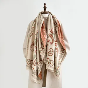 Detail of beige paisley scarf showing soft fringe and thick cashmere-like texture