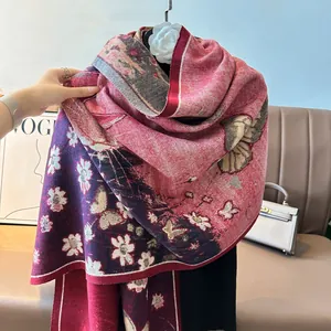 Detailed close-up of floral and butterfly patterns on a thick faux cashmere shawl