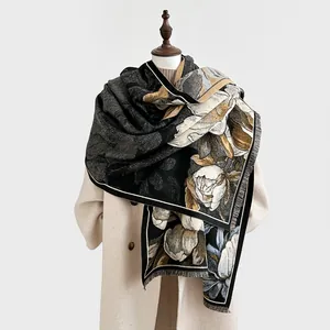 Détail d'un élégant châle floral noir et beige avec des bords à franges classiques