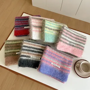 Détail d'écharpes à rayures en mélange de laine à texture brossée et étiquettes de marque