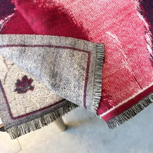Detailed macro view of woven cashmere-like scarf with cat patterns and bicolor tassels