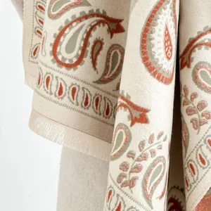 Detail of paisley pattern on beige cashmere-feel shawl with elegant fringe edges