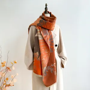 Détail d'une écharpe orange style chinois avec des franges et une texture façon cachemire