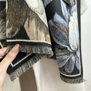 Gros plan sur la texture épaisse de l'écharpe en cachemire à fleurs et les franges