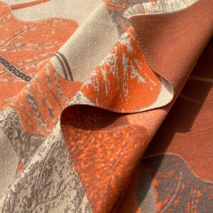 Détail d'une écharpe en jacquard avec motifs de feuilles orange et franges