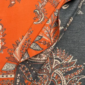 Detail of paisley jacquard pattern on double-sided thick orange and grey winter scarf