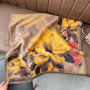 Détail d'un châle épais en imitation cachemire avec motifs floraux et franges sur canapé
