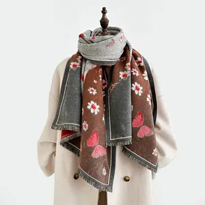 Detail of cashmere-like scarf with daisy and butterfly prints and tassel edges