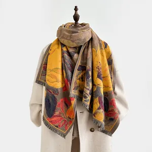 Détail d'une écharpe épaisse style cachemire avec motifs floraux vintage et franges douces