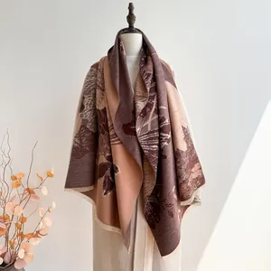 Détail macro de l'écharpe effet cachemire aux tons terreux avec motifs de feuilles