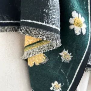 Close-up of dark green cashmere shawl with white daisy print and fringe details