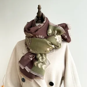 Close-up of retro floral paisley scarf with soft tassels and brown green texture