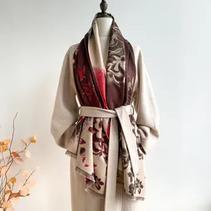 Detail of floral jacquard scarf with tassels on beige coat for autumn winter fashion