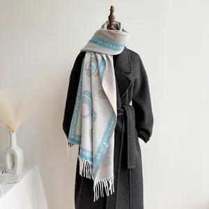 Macro detail of beige cashmere-feel shawl featuring floral patterns and soft fringe tassels