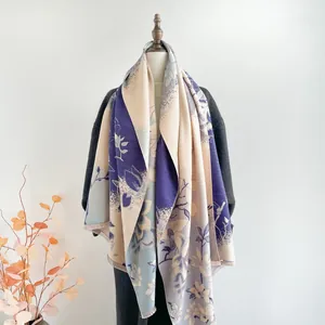 Detail of floral cashmere-like shawl with blue and purple jacquard and fringe edges