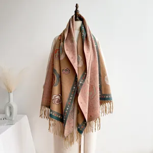 Detail of vintage camel cashmere shawl with red camellia floral pattern and soft fringe