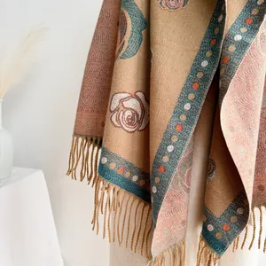 Detailed view of camel cashmere scarf featuring vintage floral jacquard and fringe edges