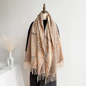 Close-up of bohemian paisley shawl showing beige jacquard texture and tassel details
