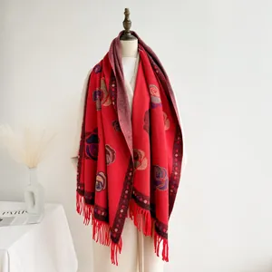 Detail of red floral cashmere shawl with vintage rose patterns and tassel fringe
