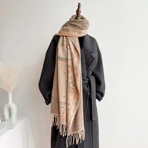 Close-up of bohemian paisley shawl with fringe detail on a grey wool coat collar