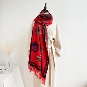 Detail of red floral scarf with fringe paired with an elegant white wool coat