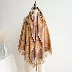 Detail of vintage bohemian shawl with yellow paisley pattern and long tassels