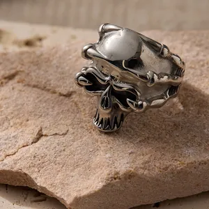 Men's punk skull ring in silver metal with polished finish on natural stone background
