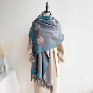 Detail of grey cashmere-feel shawl with pink camellia patterns and long tassels on edge