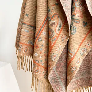 Macro detail of Bohemian shawl featuring intricate paisley patterns and fine fringe tassels