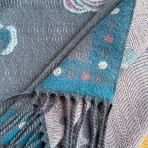 Macro detail of retro camellia shawl showing woven patterns and delicate fringe edge