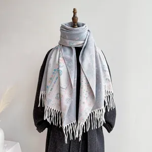 Detail of light blue bohemian pashmina shawl with floral paisley pattern and white tassels