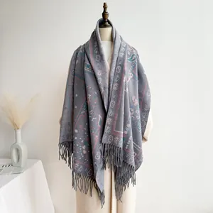 Detail of bohemian blue paisley shawl featuring intricate patterns and long tassels on edge