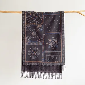 Close-up of bohemian paisley jacquard scarf with ethnic tassels hanging on wood