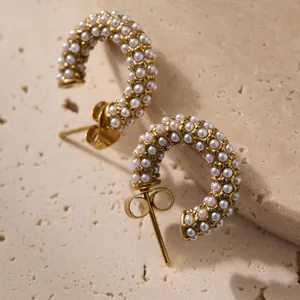 Vue détaillée des boucles d'oreilles en C plaquées or 18 carats avec perles blanches