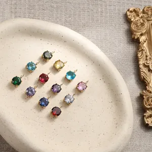 Macro shot of 14K gold plated round faceted gemstone pendants in various colors on tray
