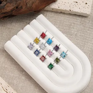 Macro detail of twelve colorful square gemstone pendants with silver claw settings for DIY