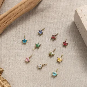 Close-up of ten colorful star-shaped gemstone charms with golden stainless steel edges